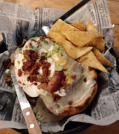 An open burger that has a lot of things including an egg